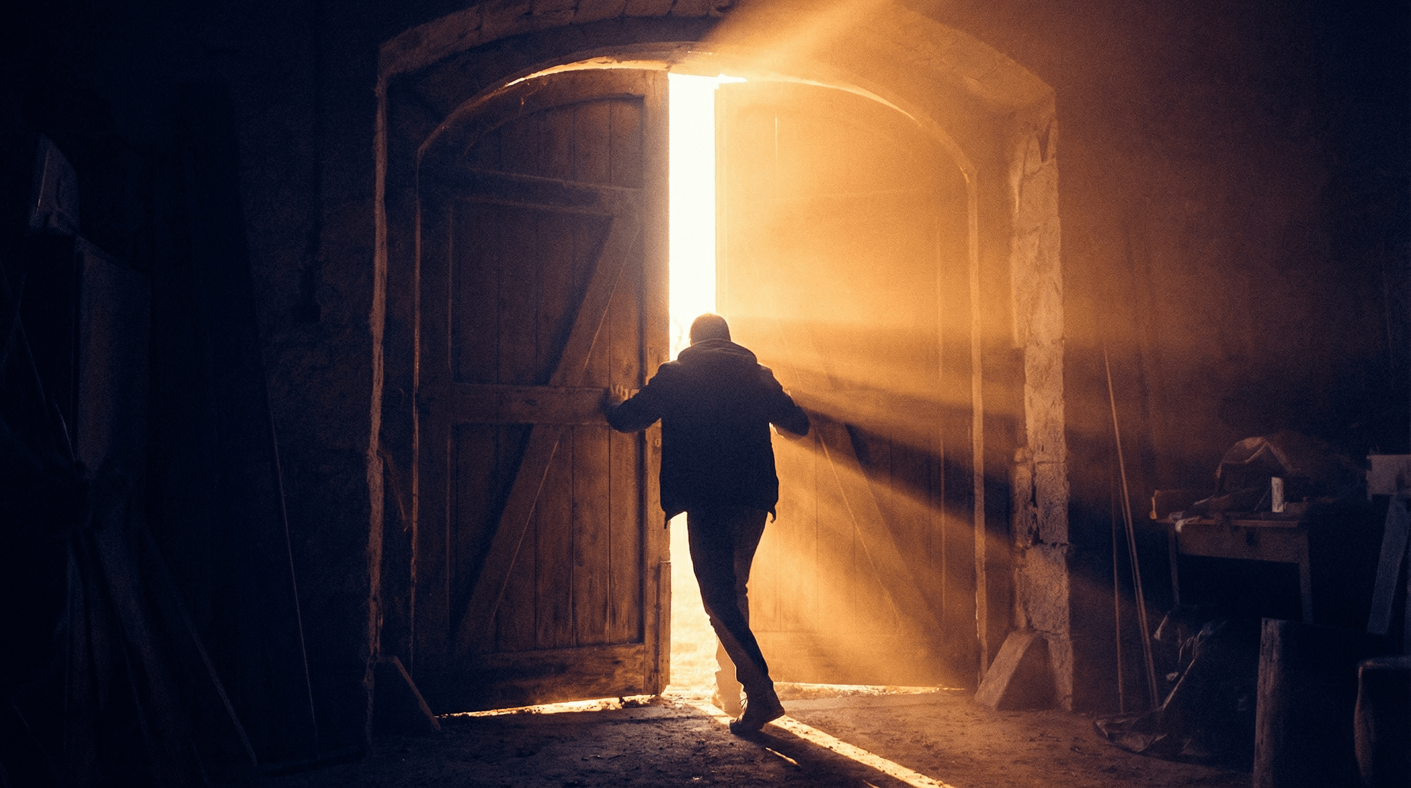 A person opening a door with light streaming through, symbolizing recovery and new beginnings